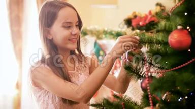 美丽的微笑少女在家中的圣诞树上挂着五颜六色的宝布尔。 家庭装饰屋